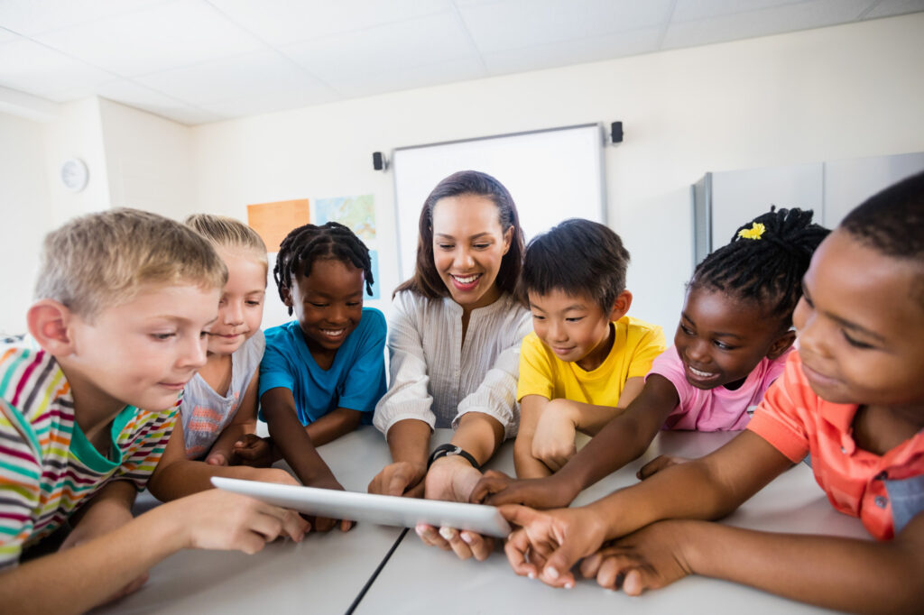 literacy teacher hold tablets during lesson with elementary school students