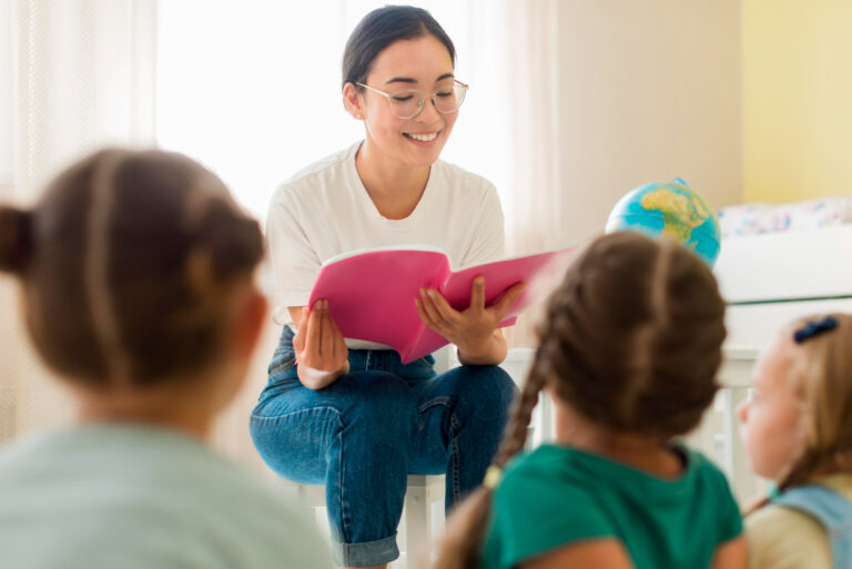 elementary school teacher reading to young students