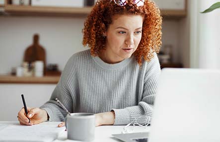 Portrait of attractive redhead caucasian businesswoman in casual clothes working from home, making business plan for launching new project, checking e-mail and financial report from her accountant