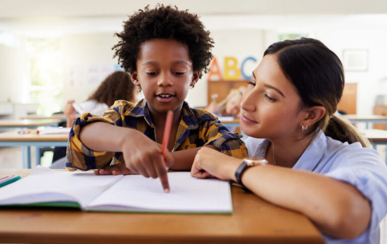 Shot of a female teacher assisting a preschool learner in her class