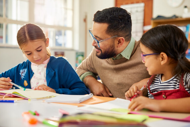 Schoolgirl asking doubt to teacher in elementary classroom